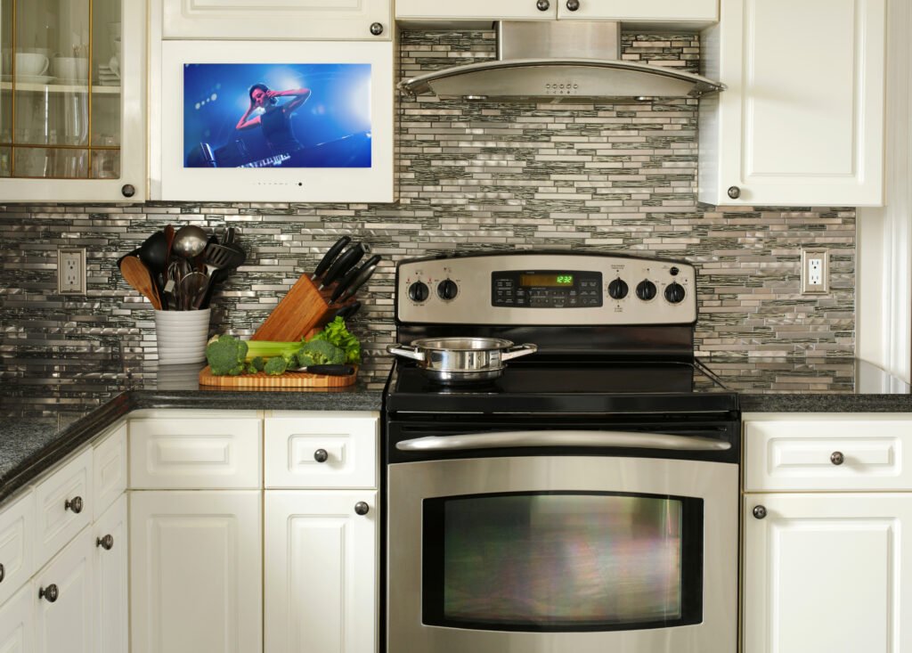 A kitchen cabinet TV installed in a modern kitchen