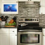 A kitchen cabinet TV installed in a modern kitchen