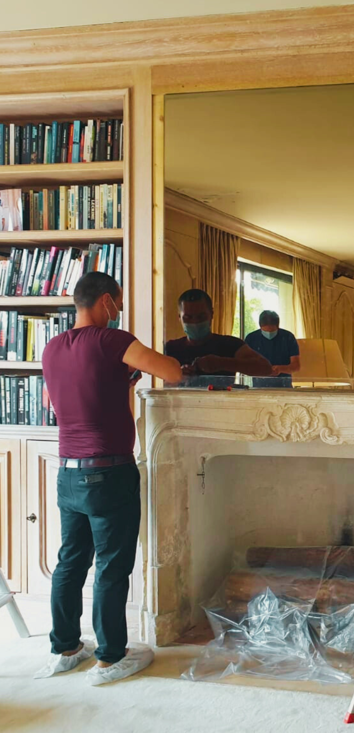 A man installing a mirror television in a living room
