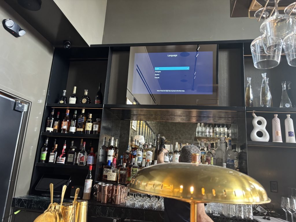 A Magic Mirror TV above a restaurant bar