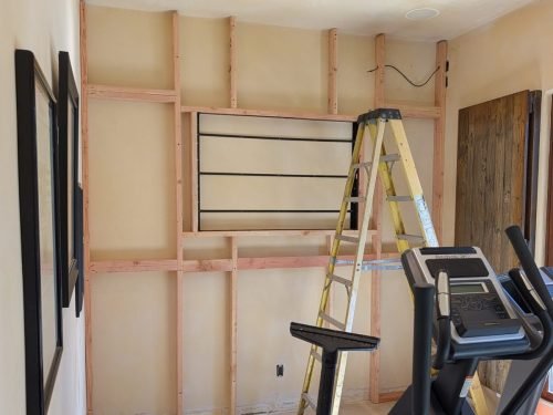 A custom built TV being fitted into a home gym